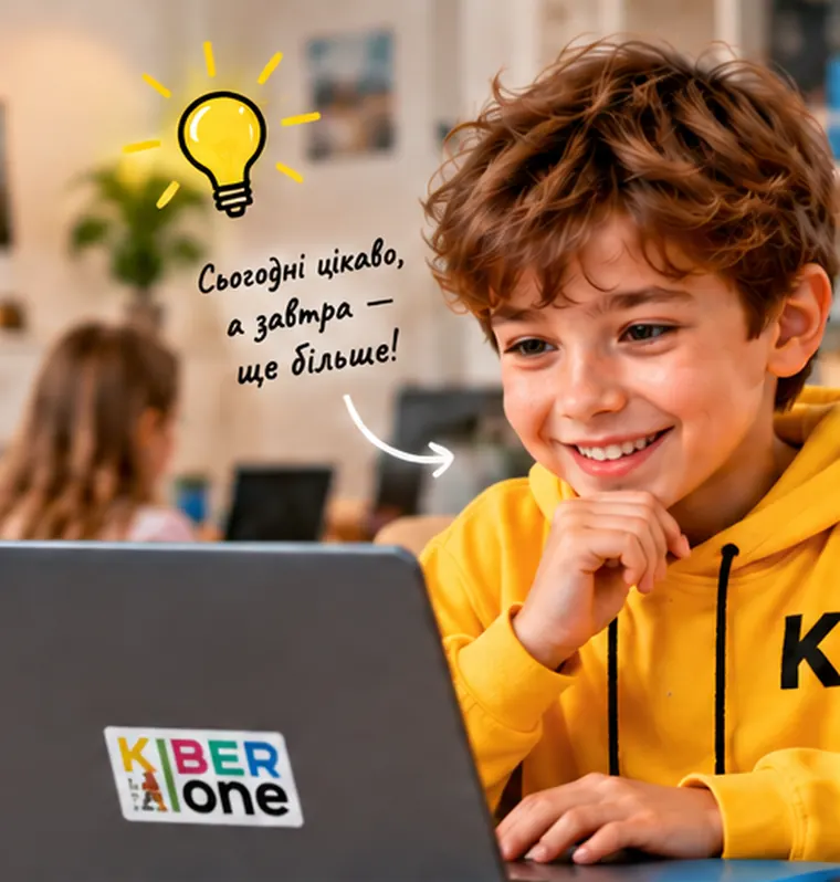Усміхнений хлопчик у худі KIBERone за ноутбуком